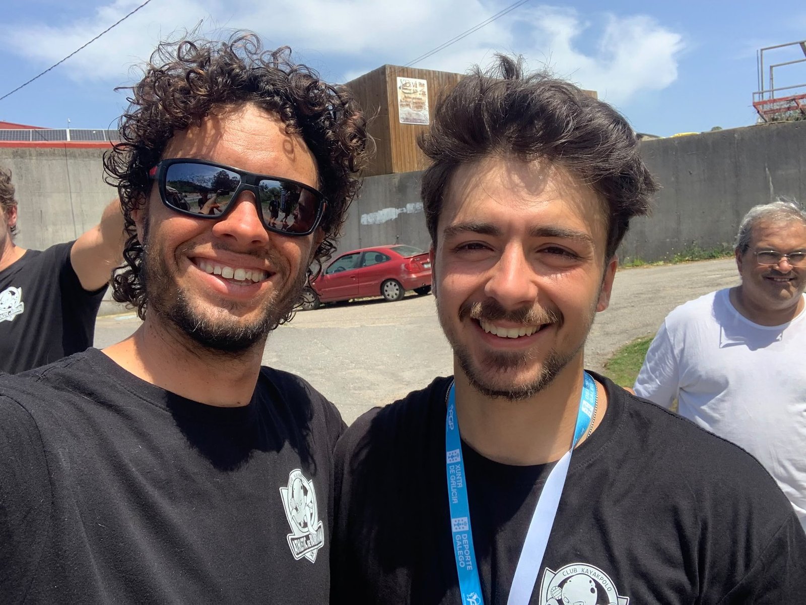 Telmo and João smiling together at the Galicia kayak polo tournament, meeting in person for the first time, Xunta de Galicia accreditation visible.