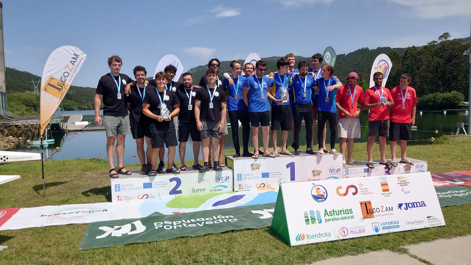 Burriana's kayak polo team on the second-place podium at the Galicia tournament, holding trophies and medals, Xunta de Galicia and Deputación de Pontevedra banners visible.
